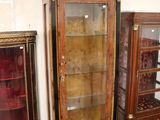 a glass display cabinet and a wooden cabinet in a room