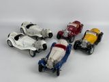 several toy cars are lined up in a row on a white surface