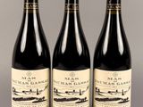trois bouteilles de vin posées sur une table l'une à côté de l'autre