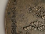 a metal plate with a bird and flowers on it