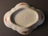 a white bowl with orange fish on it on a table