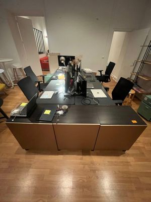 a desk with a laptop and a printer in the middle of the room