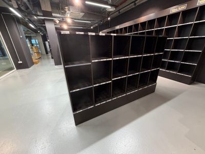une bibliothèque noire au milieu d'une pièce