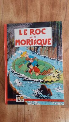 the book le roc de morbique is on a wooden table