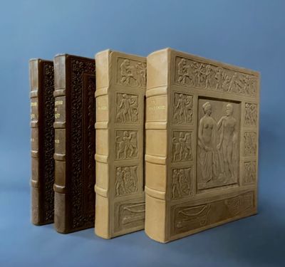 three old books with carvings on them sitting next to each other