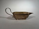un pot à lait ancien plaqué argent, muni d'une anse, sur un fond blanc
