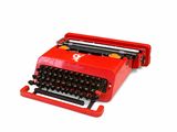 an old red typewriter sitting on top of a white surface