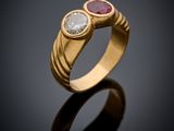 a gold ring with two ruby and white diamonds on a black surface