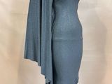 a woman in a grey dress standing on a white mannequin