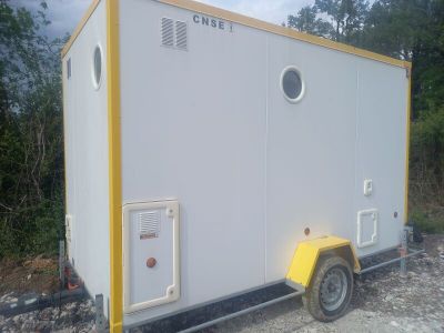 a small white and yellow portable toilet on a trailer