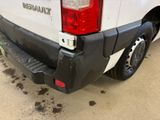 a white truck parked in a lot with dirt on the ground
