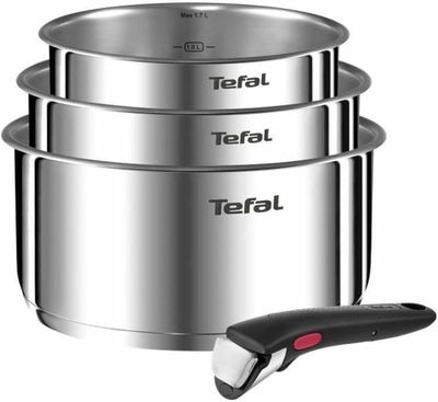 trois casseroles en acier inoxydable et une télécommande posée devant elles