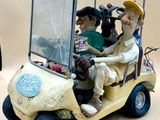 toy figurines of people riding in a golf cart on a table