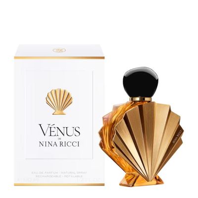 un flacon de parfum posé à côté d'une boîte sur une surface blanche