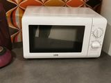 un micro-ondes blanc posé sur un plan de travail à côté d'un four à micro-ondes rose