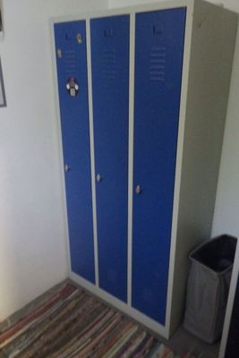 deux casiers bleus dans une pièce avec un tapis rayé