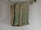 a small pouch with a belt on it on a white surface