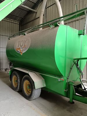 a large green tanker truck parked inside of a building