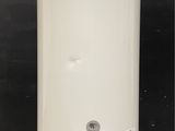 a white water heater on the floor in front of a black wall