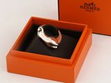 an orange box with a silver ring inside of it on a white surface