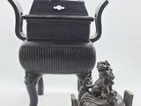 une image représentant un petit objet métallique surmonté d'une statue