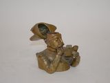 brass figurine of a man smoking a pipe with a hat on his head