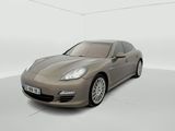 une Porsche Panamera marron garée dans une pièce blanche