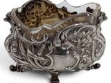 a silver bowl that is sitting on a white surface
