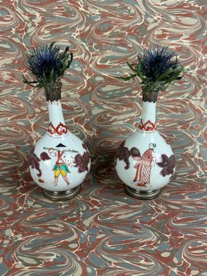 two vases with flowers in them sitting on a table