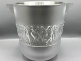 un vase en argent posé sur un socle en argent, sur une table blanche