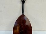 an old mandolin sitting on top of a white table next to a wall