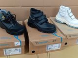 trois paires de chaussures noires et blanches exposées dans un magasin