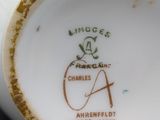 a close up of a white vase with a brown and green design