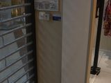 a refrigerator in the corner of a room next to a window