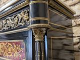 a black and gold chest of drawers with a marble top