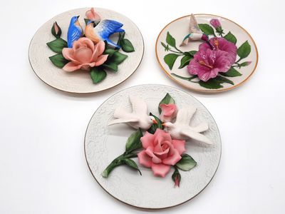 trois assiettes ornées de fleurs, posées sur un fond blanc