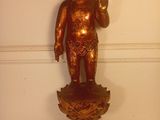 une statue en or représentant un bébé tenant une fleur