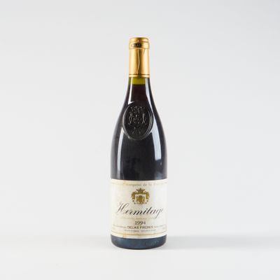 une bouteille de vin posée sur une table blanche