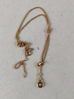a close up of a gold necklace with a black stone on it