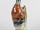 un petit canard en céramique posé sur une table