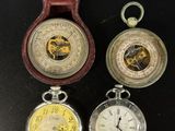 trois types différents de montres de poche dans un écrin posé sur une table