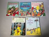quatre livres pour enfants sont alignés sur une surface blanche