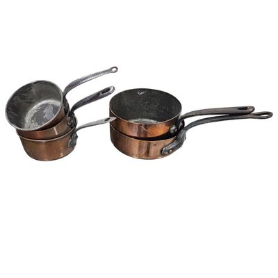three pots and pans sitting on top of each other on a white surface