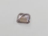 a square faceted purple diamond on a white surface