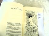 an open book with a drawing of a nude woman on it