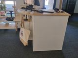 a desk with a computer on it in the corner of a room