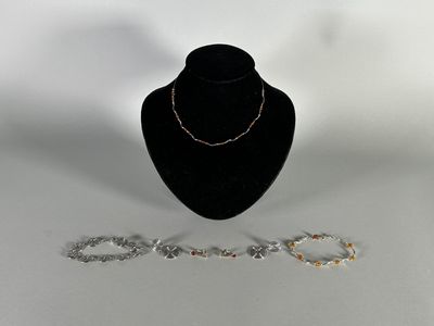 a close up of a necklace and bracelet on a mannequin