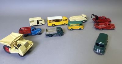 Plusieurs petites voitures et camions sont alignés sur une table