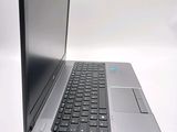 a silver laptop with a black keyboard on a white surface