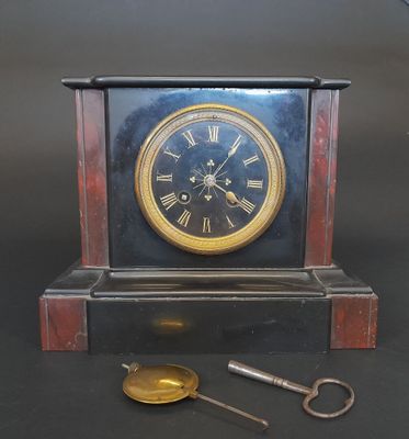 a clock that is sitting on a table with a key
